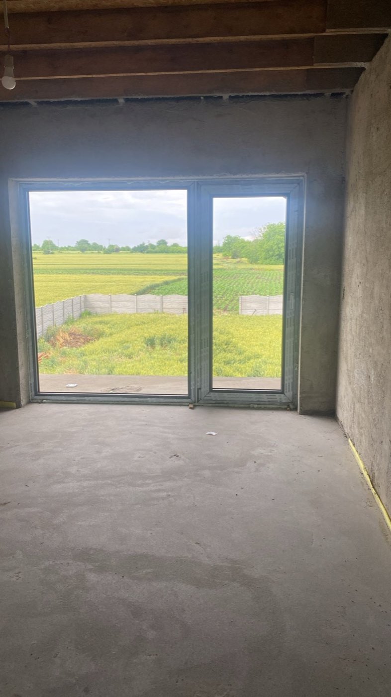 Cameră la stadiul de structură, cu ușă glisantă din termopan către grădină