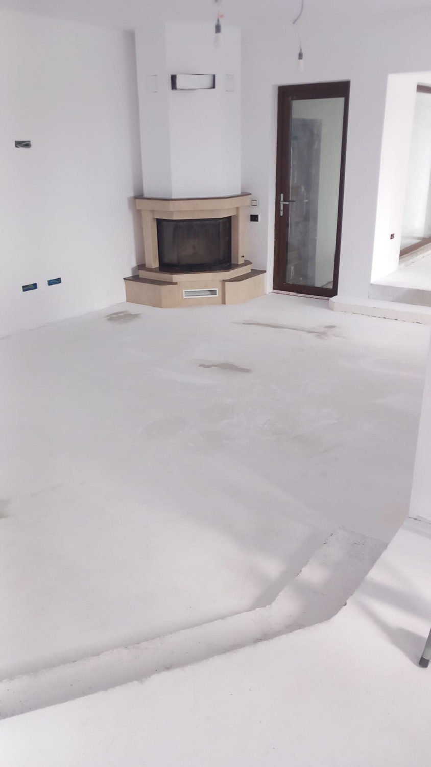 Living cu șemineu pe colț și pereți finisați, la finalul lucrărilor de renovare