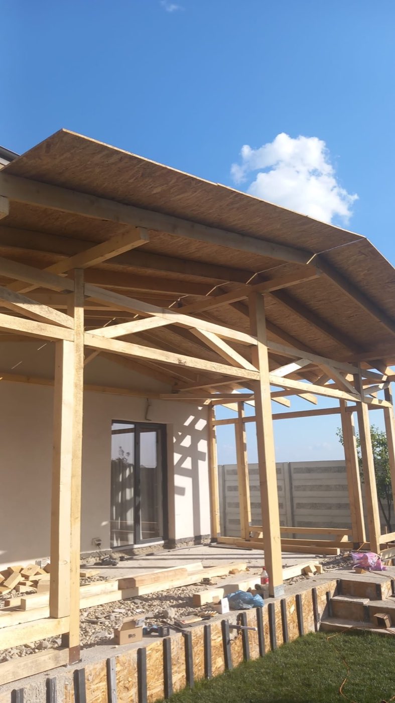 Terasă acoperită cu structură din lemn masiv și astereală OSB, la o casă nouă